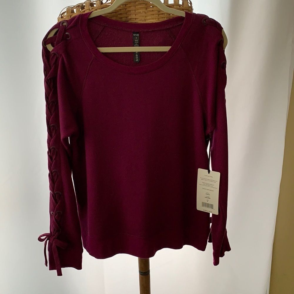 Reflex medium long sleeve and unique sweatshirt. Scoop neck and shoelace sleeves